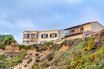 Fototapeta na wymiar Buildings on steep land with cloudy blue sky background in San Diego California