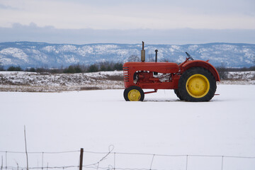 A red tractor in a snow filled farmers field