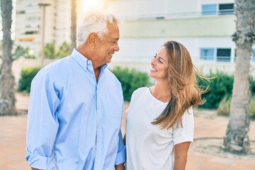 Middle age hispanic couple smiling happy standing at the promenade.