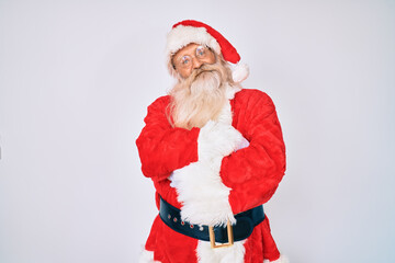 Old senior man with grey hair and long beard wearing santa claus costume happy face smiling with crossed arms looking at the camera. positive person.