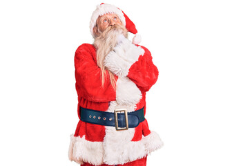 Old senior man with grey hair and long beard wearing traditional santa claus costume with hand on chin thinking about question, pensive expression. smiling and thoughtful face. doubt concept.