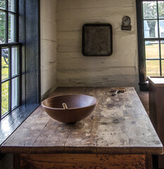 Simple rural farmhouse kitchen with wooden table and bowl in vertical orientation. This is a...