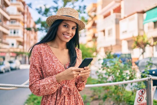 Young african american tourist woman on vacation smiling happy using smartphone at the city.