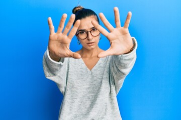 Fototapeta premium Young hispanic woman wearing casual clothes doing frame using hands palms and fingers, camera perspective