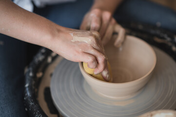 Potter makes the clay product with pottery modeling tools on the potter's wheel.