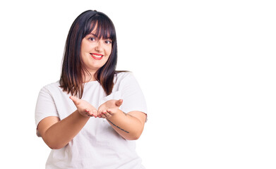 Young plus size woman wearing casual clothes smiling with hands palms together receiving or giving gesture. hold and protection