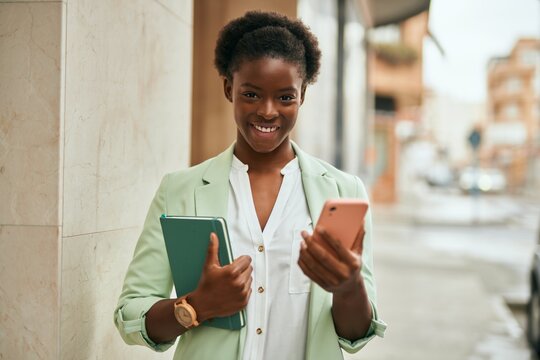Young african american businesswoman smiling happy using smartphone at the city.