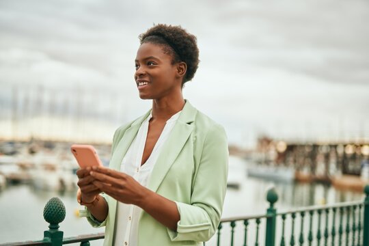 Young african american businesswoman smiling happy using smartphone at the city.