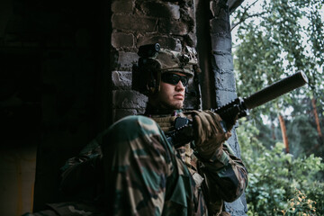 Fototapeta premium Brutal military man is sitting and cleaning and preparing his gun to the battle.