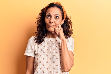 Middle age beautiful woman wearing casual t shirt thinking concentrated about doubt with finger on chin and looking up wondering