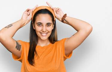 Fototapeta na wymiar Young hispanic woman wearing casual clothes posing funny and crazy with fingers on head as bunny ears, smiling cheerful