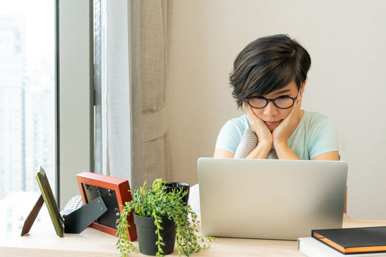 A young beautiful and stylish asian woman using computer laptop to remote online working from home during Covid 19 pandemic lockdown. New normal, Self isolation, Lifestyle, Home office, Freelancer. 