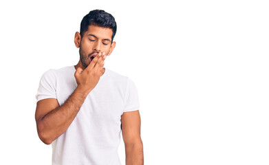 Young latin man wearing casual clothes bored yawning tired covering mouth with hand. restless and sleepiness.