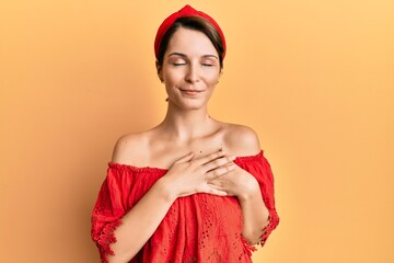 Young brunette woman with short hair wearing casual clothes smiling with hands on chest with closed eyes and grateful gesture on face. health concept.