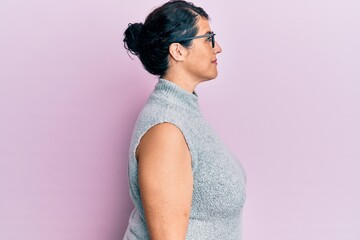 Plus size brunette woman wearing casual clothes and glasses looking to side, relax profile pose...