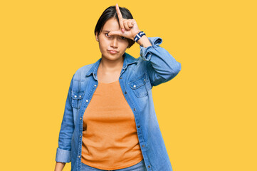 Young beautiful hispanic woman with short hair wearing casual denim jacket making fun of people...