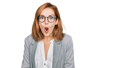 Fototapeta premium Young caucasian woman wearing business style and glasses afraid and shocked with surprise and amazed expression, fear and excited face.