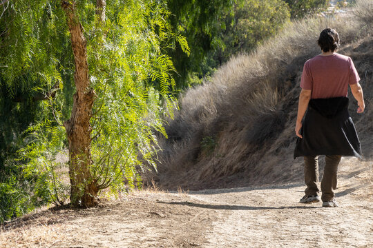 Young Single Man Hiking On Trail Outside For Exercise In Urban Area Surrounded By Trees 