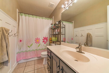 Bathroom interior of home with floral shower curtain concealing the bathtub