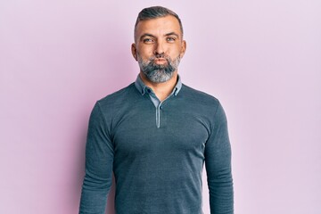 Obraz premium Middle age handsome man wearing casual clothes puffing cheeks with funny face. mouth inflated with air, crazy expression.