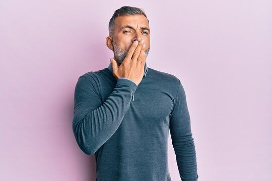 Middle age handsome man wearing casual clothes bored yawning tired covering mouth with hand. restless and sleepiness.