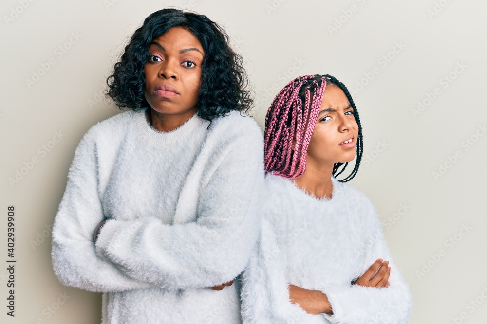 Poster Beautiful african american mother and daughter with arms crossed gesture clueless and confused expression. doubt concept.