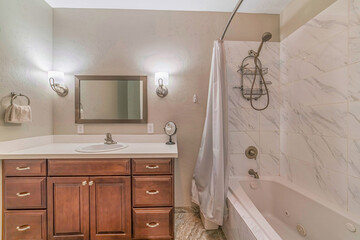 Sink over cabinets and built in bathtub with shower inside bathroom of a home