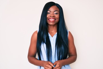Fototapeta premium Young african american woman wearing casual clothes looking positive and happy standing and smiling with a confident smile showing teeth