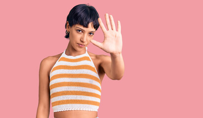 Young brunette woman with short hair wearing casual clothes doing stop sing with palm of the hand....