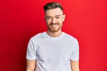 Young redhead man wearing casual white t shirt with a happy and cool smile on face. lucky person.