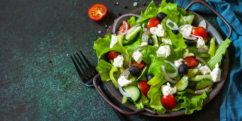 Healthy diet food. Greek salad of feta cheese, fresh cucumber, tomato, sweet pepper, lettuce, red onion and olives with olive oil. Banner.