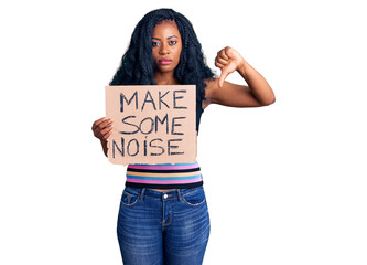 Beautiful african american woman holding make some noise banner with angry face, negative sign...