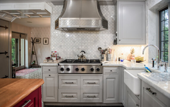 Contemporary Kitchen With Gray, White And Maroon Colors And Stainless Steel Stove And Hood.