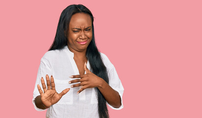 Young black woman wearing casual clothes disgusted expression, displeased and fearful doing disgust face because aversion reaction. with hands raised