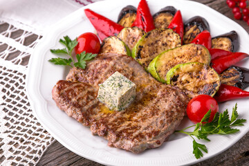 Pork steak grilled with grilled vegetables. Balkan cuisine. National cuisine. Nourishing, useful, natural. Rustic cuisine.