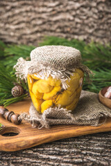 Delicious preserved marinated small yellow summer squash, also known as patty pan squash in the glass jar. Rustic style