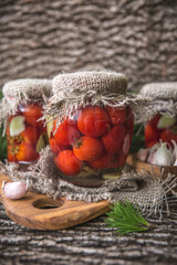 Preserved autumn vegetables. Delicious preserved marinated tomatoes in the glass jar. Rustic style