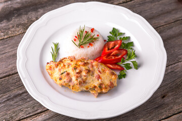 Chicken fillet baked in cheese with rice and vegetables. Balkan cuisine. National cuisine. Nourishing, useful, natural. Rustic cuisine.