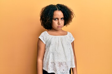 Young little girl with afro hair wearing casual clothes skeptic and nervous, frowning upset because...