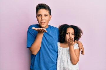 Obraz premium Young hispanic family of brother and sister wearing casual clothes together looking at the camera blowing a kiss with hand on air being lovely and sexy. love expression.