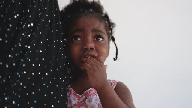 African American little girl is crying and stand near her mother and look around with stay on her house. Concept of sad emotion of children should support by family.