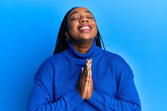 Young african american woman wearing casual winter sweater begging and praying with hands together with hope expression on face very emotional and worried. begging.