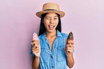 Young chinese woman wearing summer style holding ice cream winking looking at the camera with sexy...