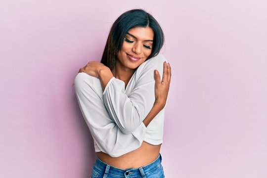 Young latin transsexual transgender woman wearing casual clothes hugging oneself happy and positive, smiling confident. self love and self care