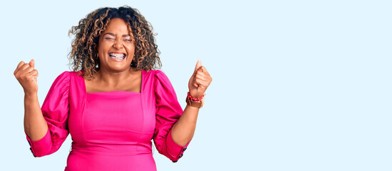 Young african american plus size woman wearing casual clothes screaming proud, celebrating victory...