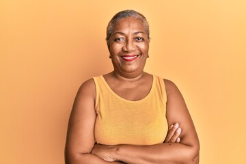 Senior african american woman wearing casual style with sleeveless shirt happy face smiling with crossed arms looking at the camera. positive person. - Powered by Adobe