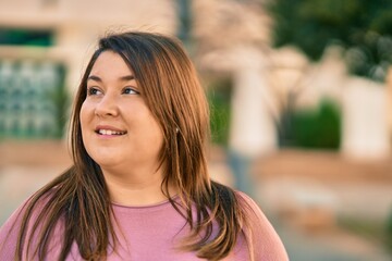 Obraz premium Young hispanic plus size woman smiling happy standing at the city.