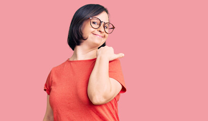 Brunette woman with down syndrome wearing casual clothes and glasses smiling with happy face...
