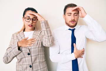 Beautiful couple wearing business clothes touching forehead for illness and fever, flu and cold, virus sick