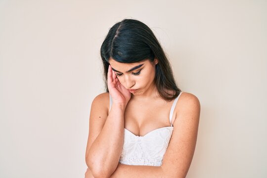 Brunette teenager girl posing elegant thinking looking tired and bored with depression problems with crossed arms.